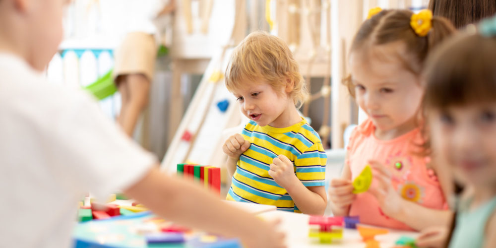 Group of children playing together in the classroom in kindergarten or preschool